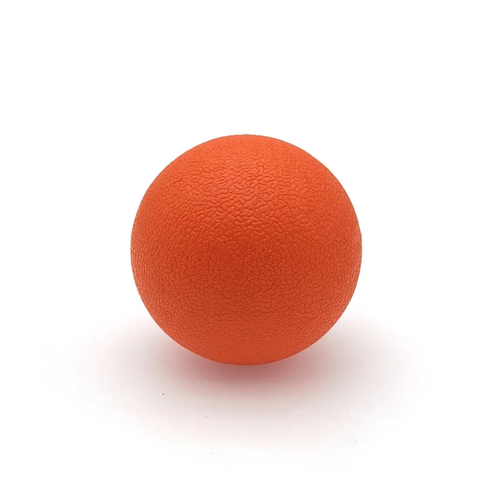 An orange TPE peanut massage ball resting on a white surface.
