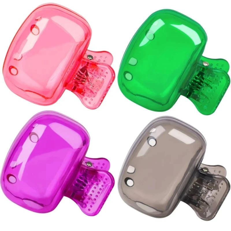Three silicone toothbrush head covers in pink, green, and purple with clips shown from above.