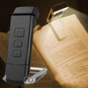 A black rechargeable clip-on LED book light with a flexible neck resting on an open book.