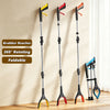 Three black grabber reachers with yellow and red tips are displayed against a light wall.