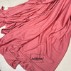 A flowing piece of elegant pink or rose-colored stretch jersey fabric draped in soft folds.