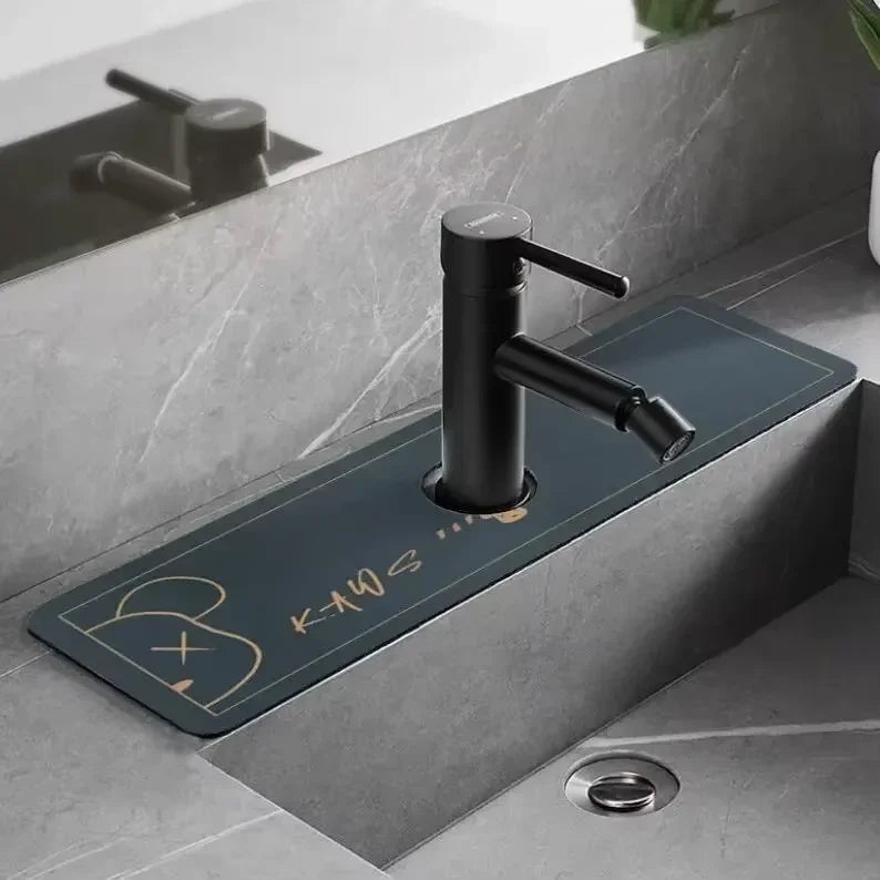 A matte black faucet mounted on a dark blue mat in a modern bathroom setting.