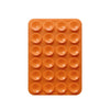 An orange silicone suction pad with multiple circular pads for phone mounts.