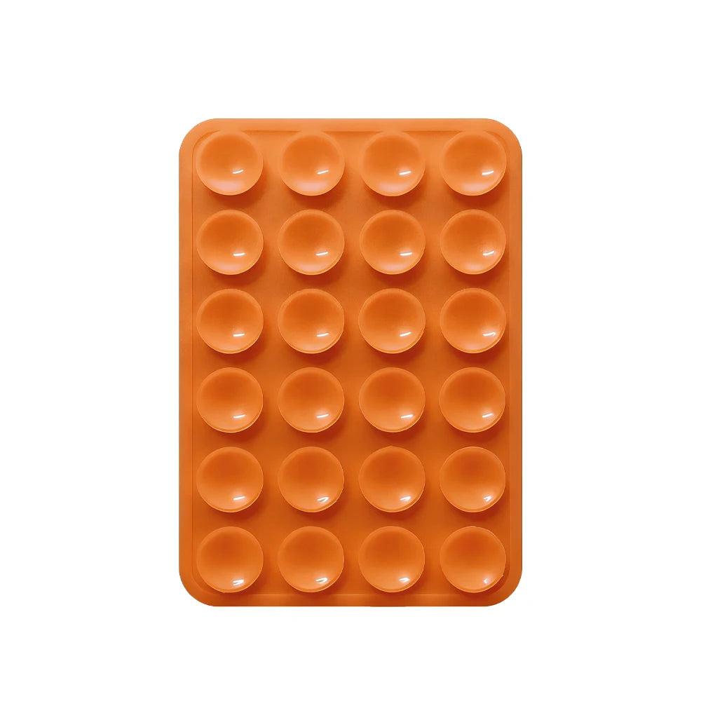 An orange silicone suction pad with multiple circular pads for phone mounts.