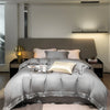 Luxuriöses Bambus-Bettwäsche-Set mit grauem Duvet und Kissen auf einem modernen Bett.