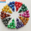 A collection of seven polyhedral dice in various colors including red, blue, yellow, and green arranged in a circle.