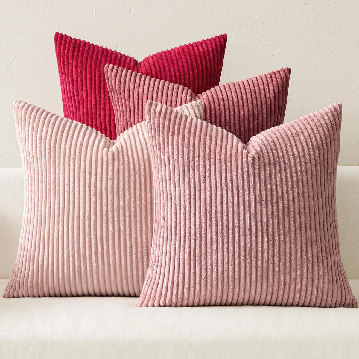 Three textured throw pillows in shades of pink and coral corduroy fabric