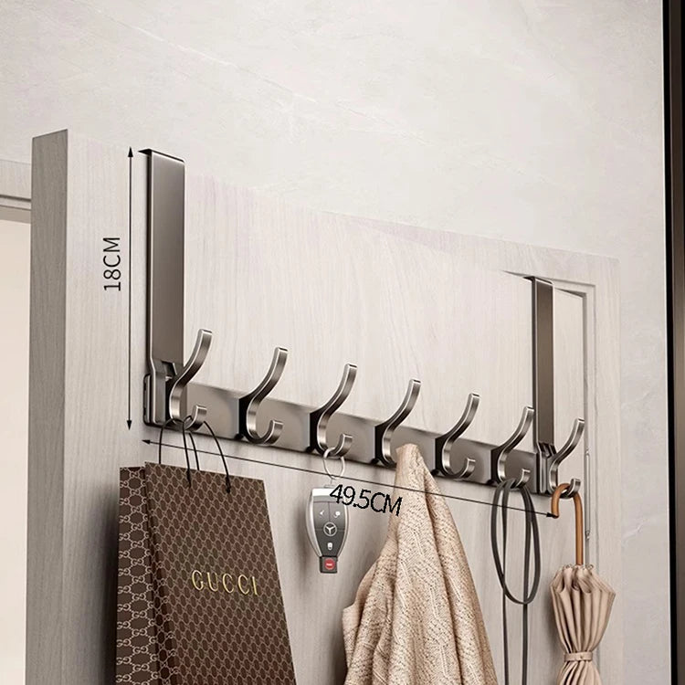 A silver over-the-door organizer rack with eight hooks mounted on a light gray wall.