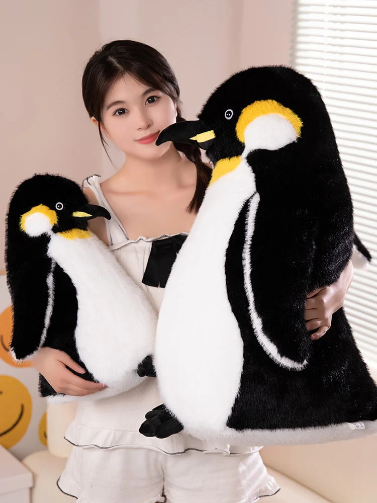 A woman is holding a black and white penguin plush toy.