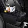 A black car armrest cushion with storage and cup holders featuring a quilted texture, holding a bottle and a cup.