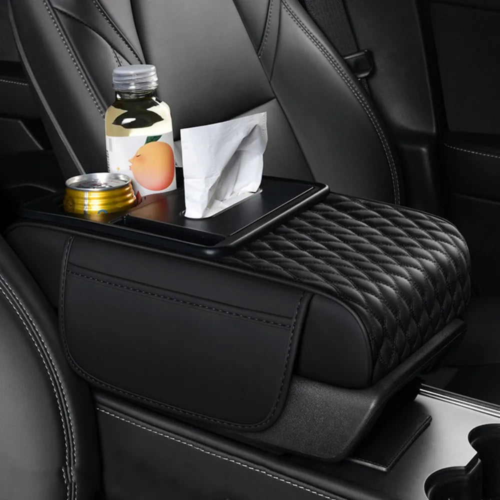 A black car armrest cushion with storage and cup holders featuring a quilted texture, holding a bottle and a cup.