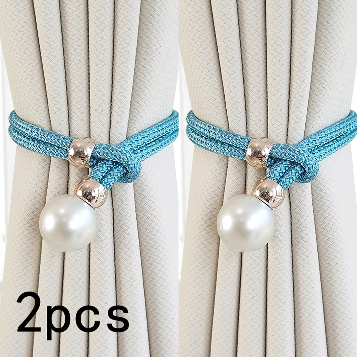 A set of two turquoise rope and pearl curtain tie-backs used to secure light beige curtains.