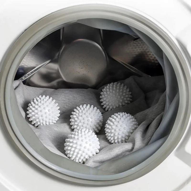 A close-up view inside a white container showing reusable white laundry balls nestled in a gray cloth.