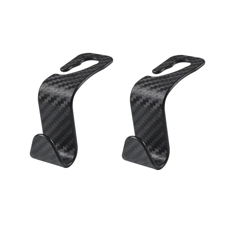 A pair of black carbon fiber headrest hooks used for storing bags, clothes, and other items.