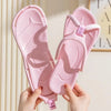 A pair of pink foldable EVA travel slippers being held by hands.