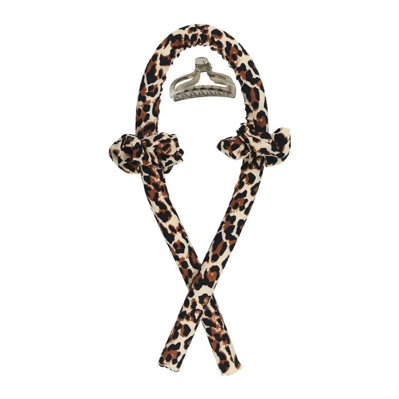 Diadema sin calor de seda con estampado de leopardo negro y marrón y clip metálico.