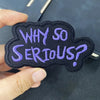 A dark purple embroidered patch shaped like a cloud with the text WHY SO SERIOUS?