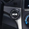 Close-up of a black rotating protective cover for a car ignition start button on a vehicle dashboard.