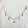 Gold alloy chain with pink starfish and seashell charms on a white background