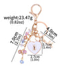 Gold-toned keychain featuring a bow, heart, and key charms with various colored rhinestones.