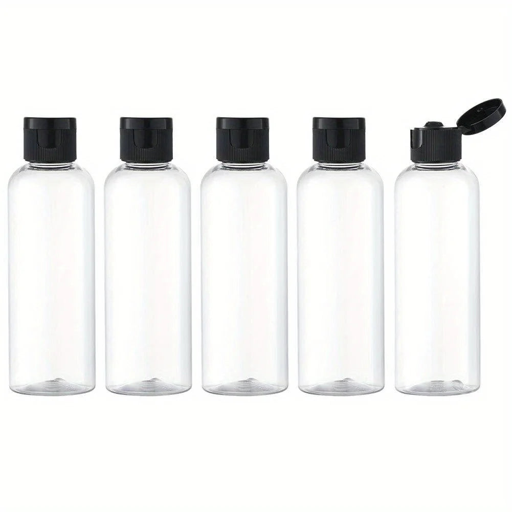 Five clear glass refillable travel bottles with flip caps arranged in a row.