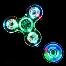 A glowing green and blue LED fidget spinner with multiple rotating lights against a black background.