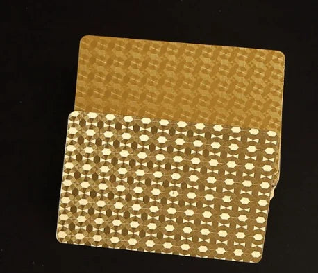 A deck of luxury gold foil playing cards with a matte finish shown against a dark background.