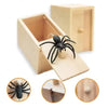 A wooden box with a pop-out feature revealing a black spider toy.