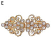 Vintage gold-toned swirl clip featuring clear rhinestones, designed for cardigans and shawls.
