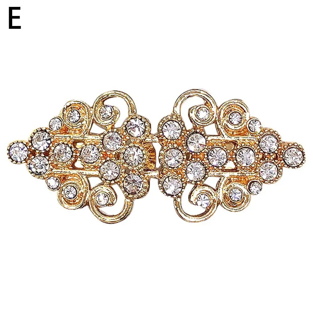 Vintage gold-toned swirl clip featuring clear rhinestones, designed for cardigans and shawls.