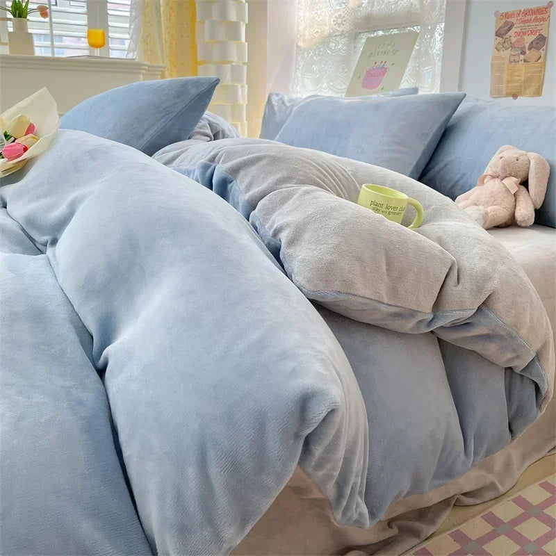 A cozy milk velvet bedding set featuring a duvet cover and pillows in soft blue and gray tones.