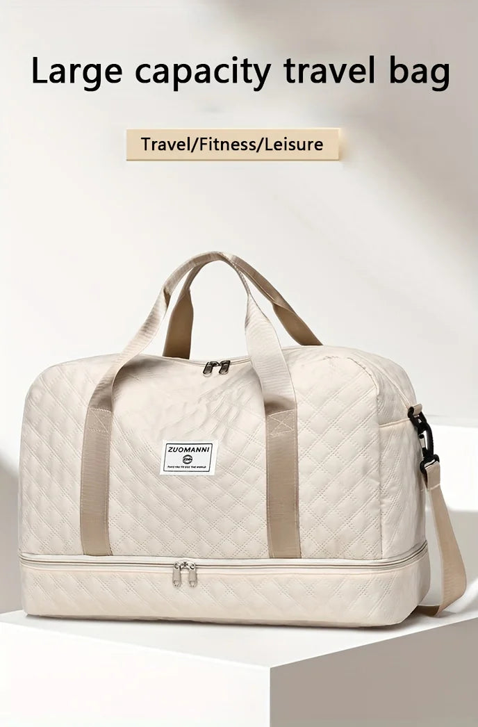 A beige quilted large capacity travel bag with tan straps resting on a white surface.