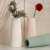 A white silicone mold is shown next to a pink vase and a red rose against a light background.