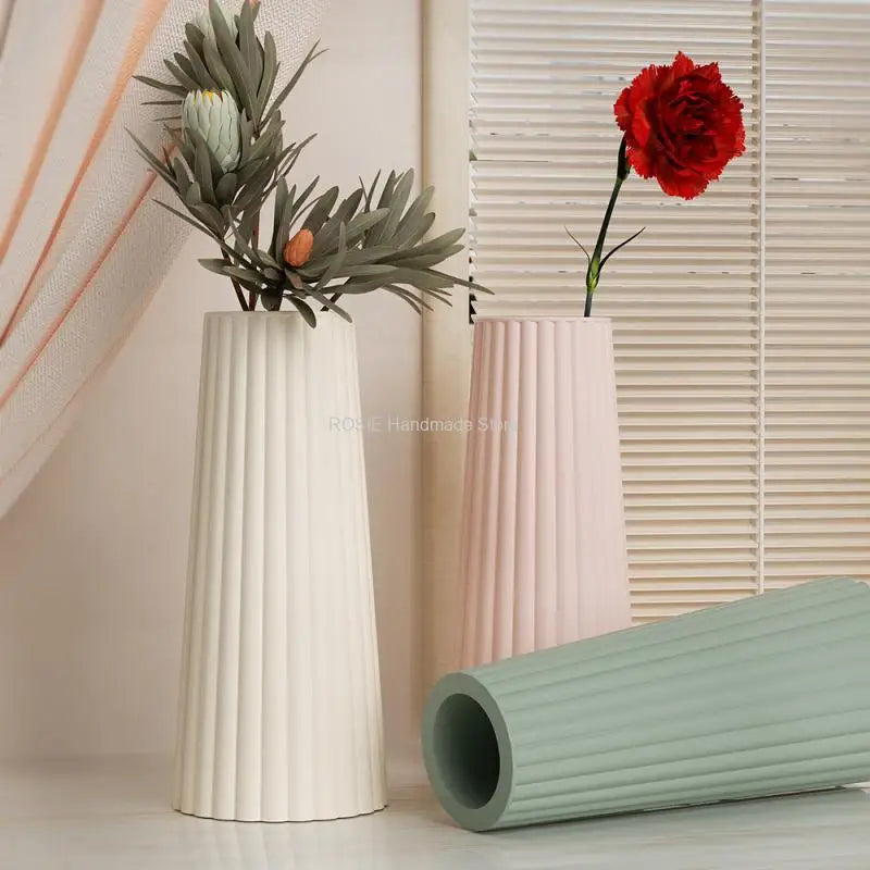 A white silicone mold is shown next to a pink vase and a red rose against a light background.