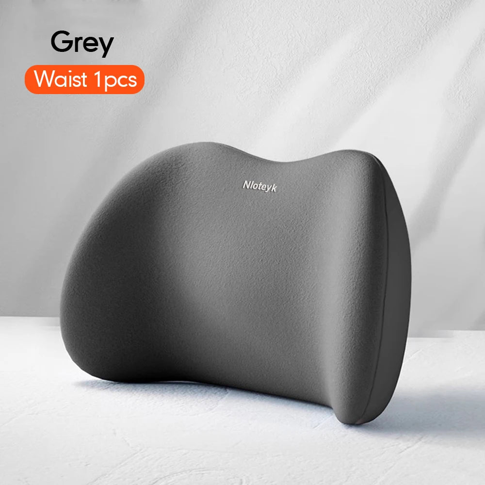 A grey memory foam car headrest and lumbar support pillow shown on a white surface.