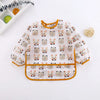 A white long-sleeve baby feeding smock with a repeating pattern of cute animal faces.