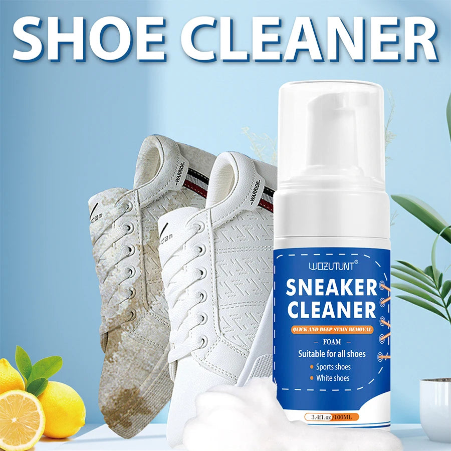 Botella de espuma limpiadora para zapatos blanca junto a un par de zapatillas blancas y un limón.