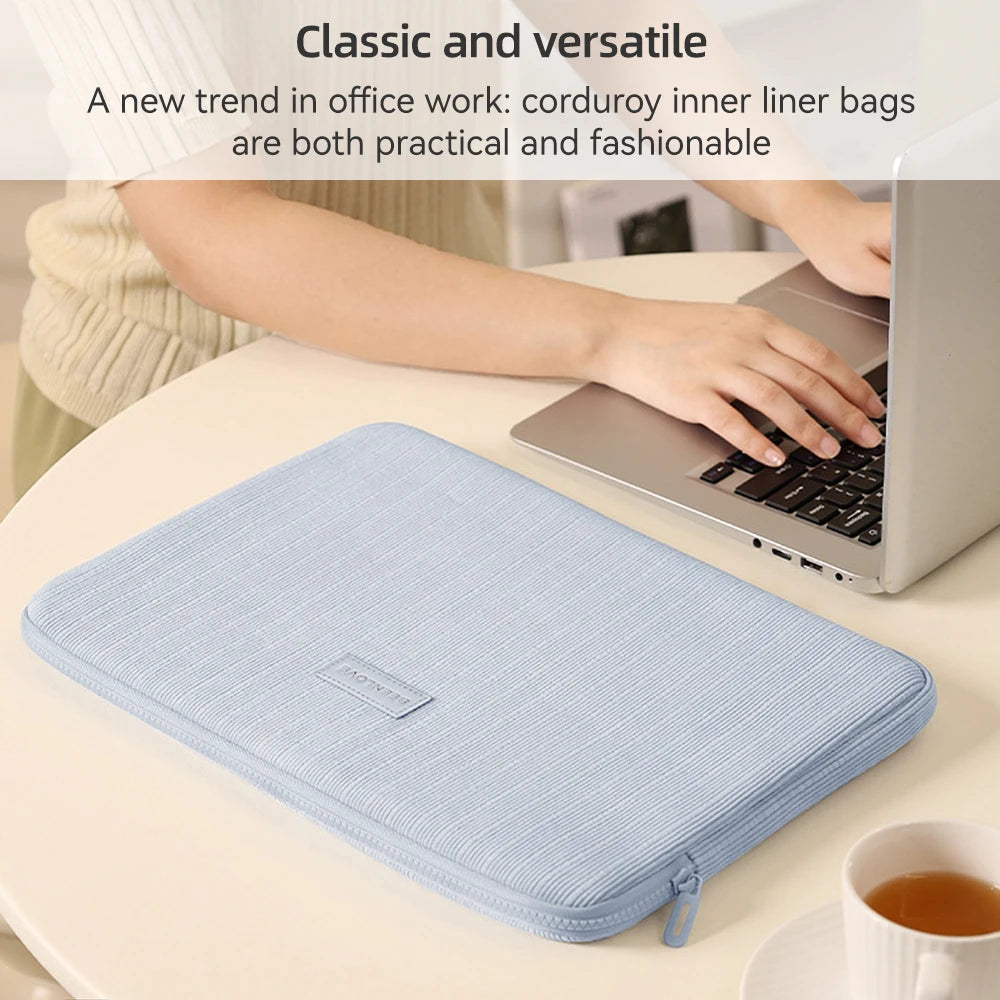 Una funda protectora a rayas azul claro para una laptop colocada en una mesa blanca.