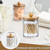 Clear glass storage box with bamboo lid filled with white toothbrushes and other bathroom items