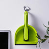 A bright lime green compact handheld dustpan and brush set against a white background.