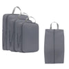 A set of three gray compressible packing cubes for travel organization.