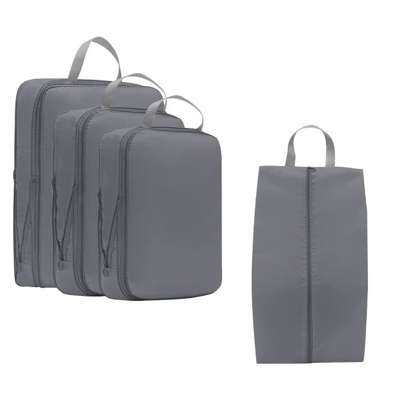 A set of three gray compressible packing cubes for travel organization.