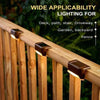 Close-up of a solar powered LED step light mounted on a wooden fence railing for outdoor lighting.