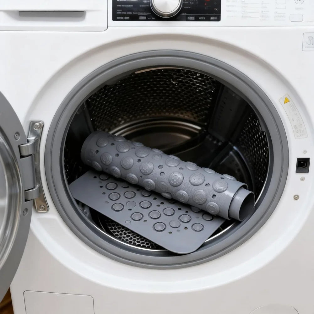 A close-up view of a gray non-slip suction cup bath mat with massage nodes inside a white washing machine drum.