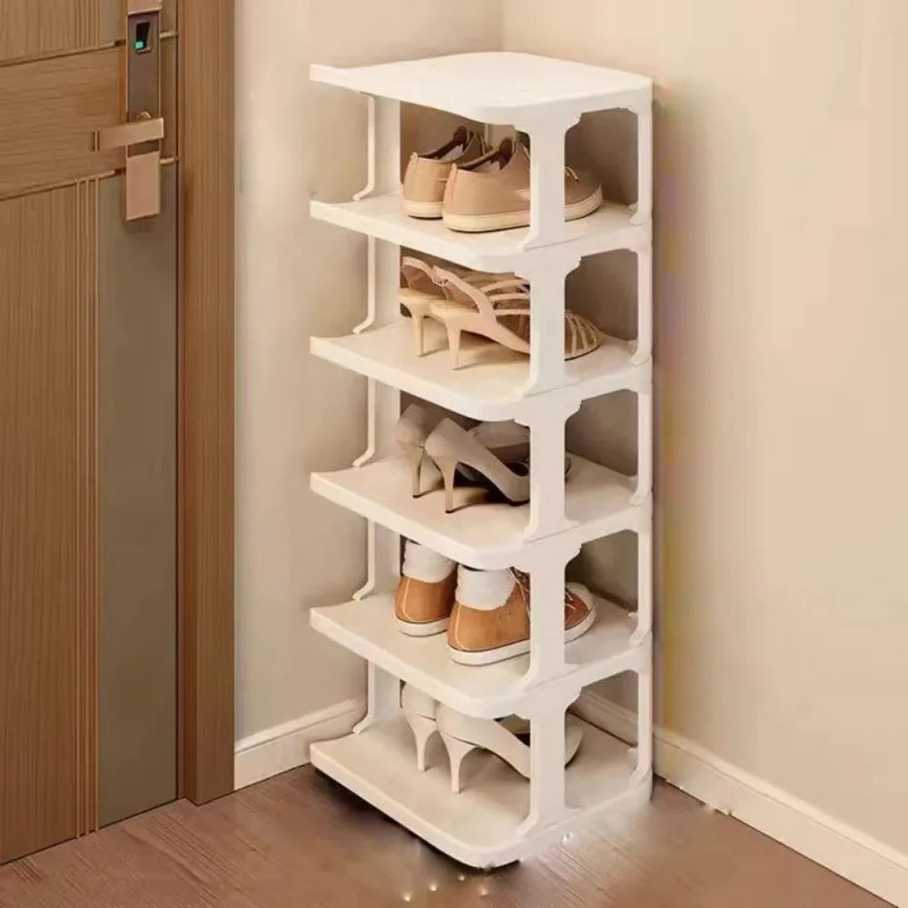 A white stackable vertical shoe rack with multiple tiers is shown next to a wooden door.