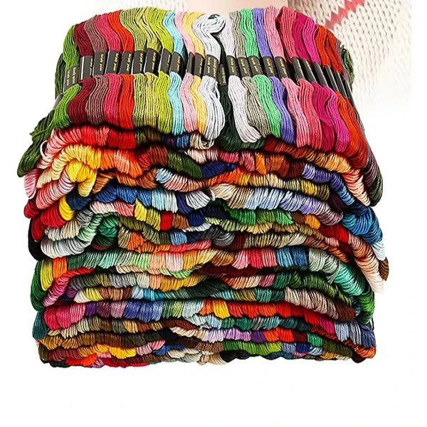 A large pile of assorted cotton embroidery floss in various colors and shades stacked together.