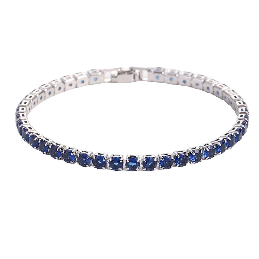 A silver tennis bracelet set with blue gemstones and cubic zirconia stones.