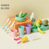A set of colorful kitchen tools and produce, including a yellow corn cob, green peppers, and various plastic utensils, arrang