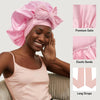 A woman wearing a pink satin sleeping bonnet with elastic bands and long straps.