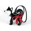 Black and white Shiba Inu PU leather bag charm with a red braided bow on a black leather strap